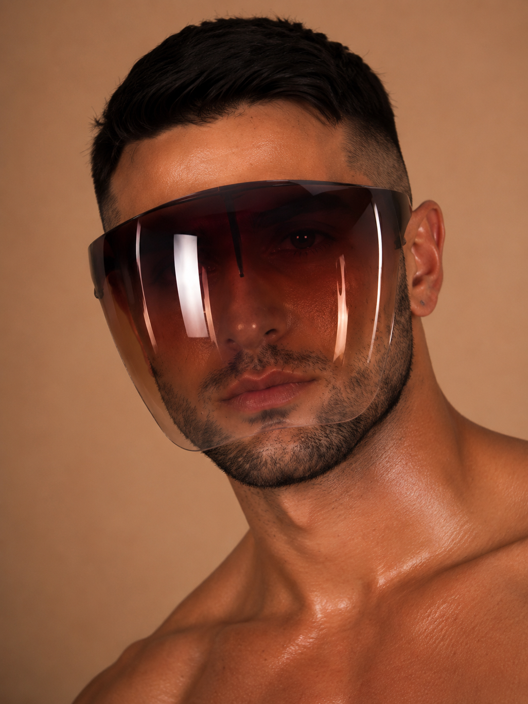the shield, oversized gradient amber face shield worn straight to camera, warm backdrop