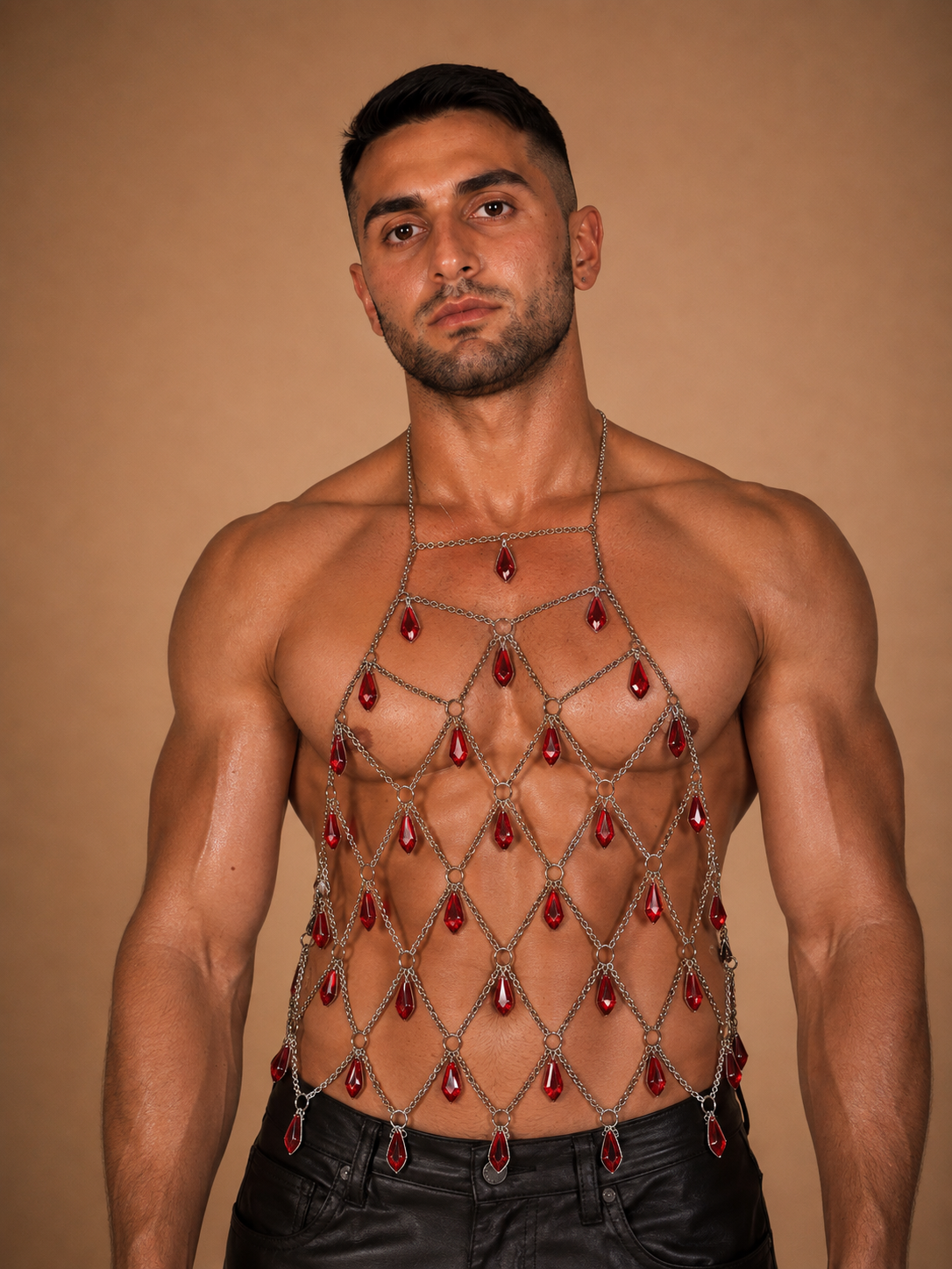 the chandelier, silver chain-mesh top with red crystal teardrops worn over bare chest, warm backdrop