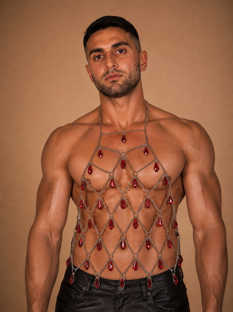 the chandelier, silver chain-mesh top with red crystal teardrops worn over bare chest, warm backdrop